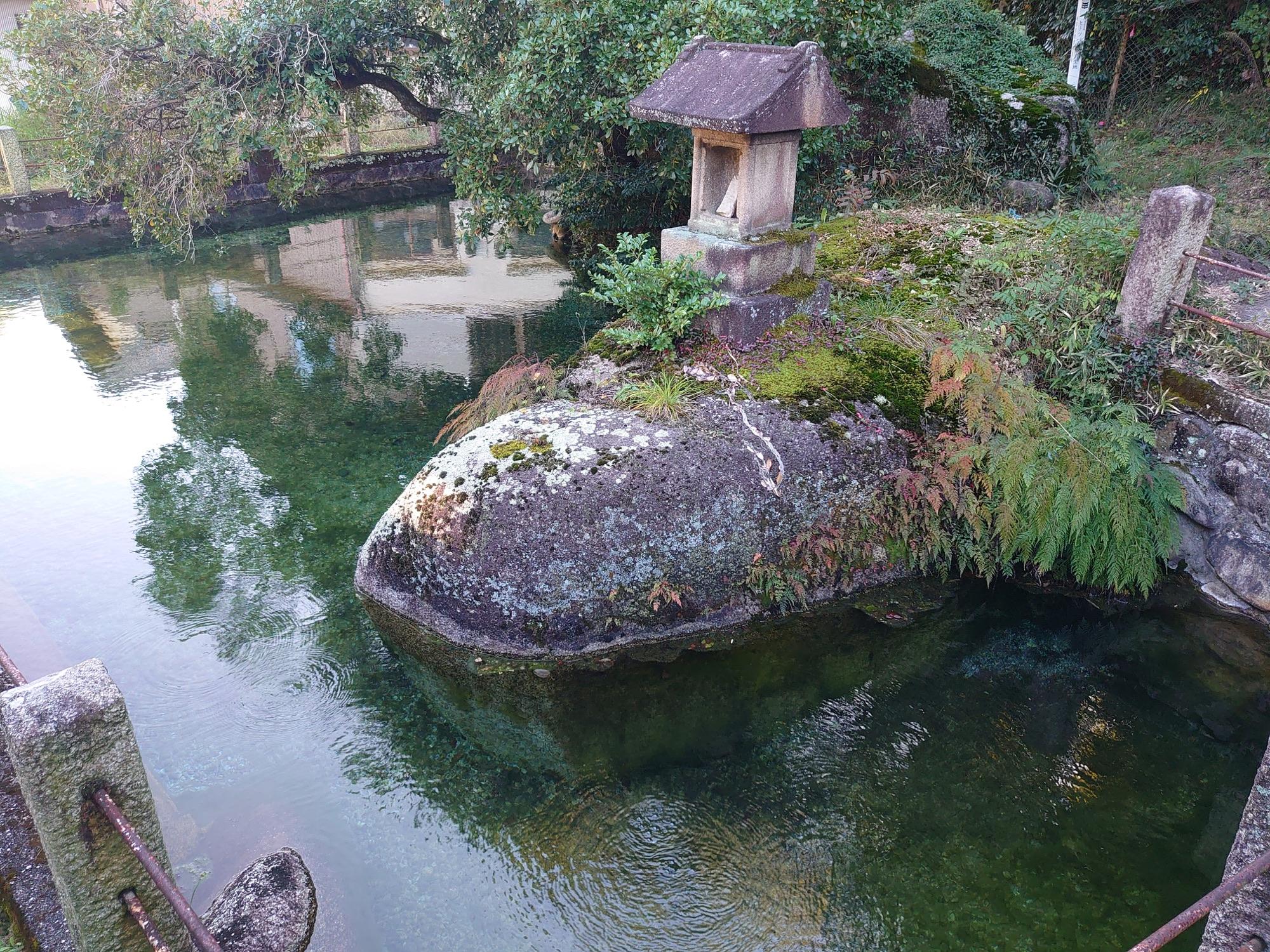 岩と祠の周囲に透明な水が湧く白狐温泉神明水